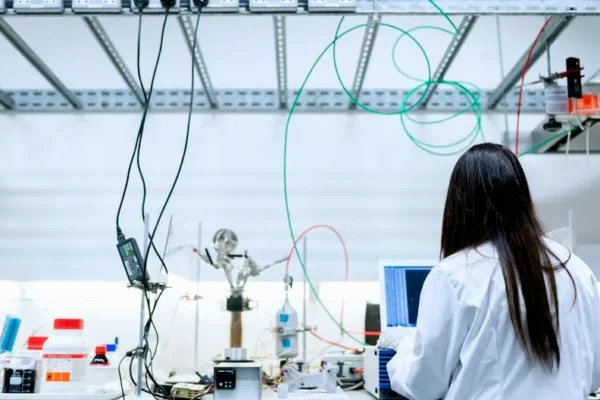 A female scientist conducting research in a contemporary laboratory full of equipment.