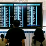 a group of people standing in front of a large screen