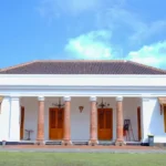 a large white building with columns and wooden doors