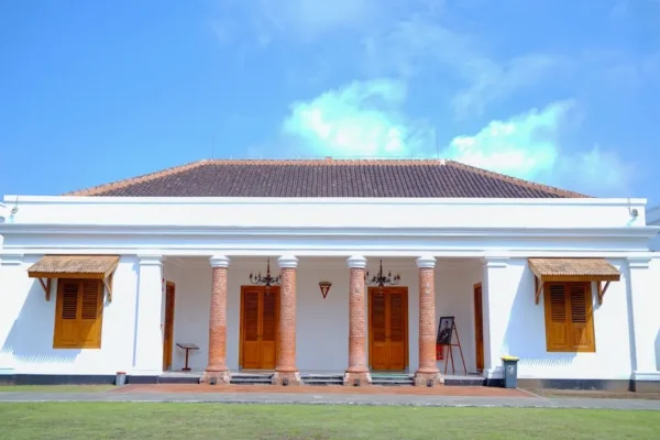 a large white building with columns and wooden doors