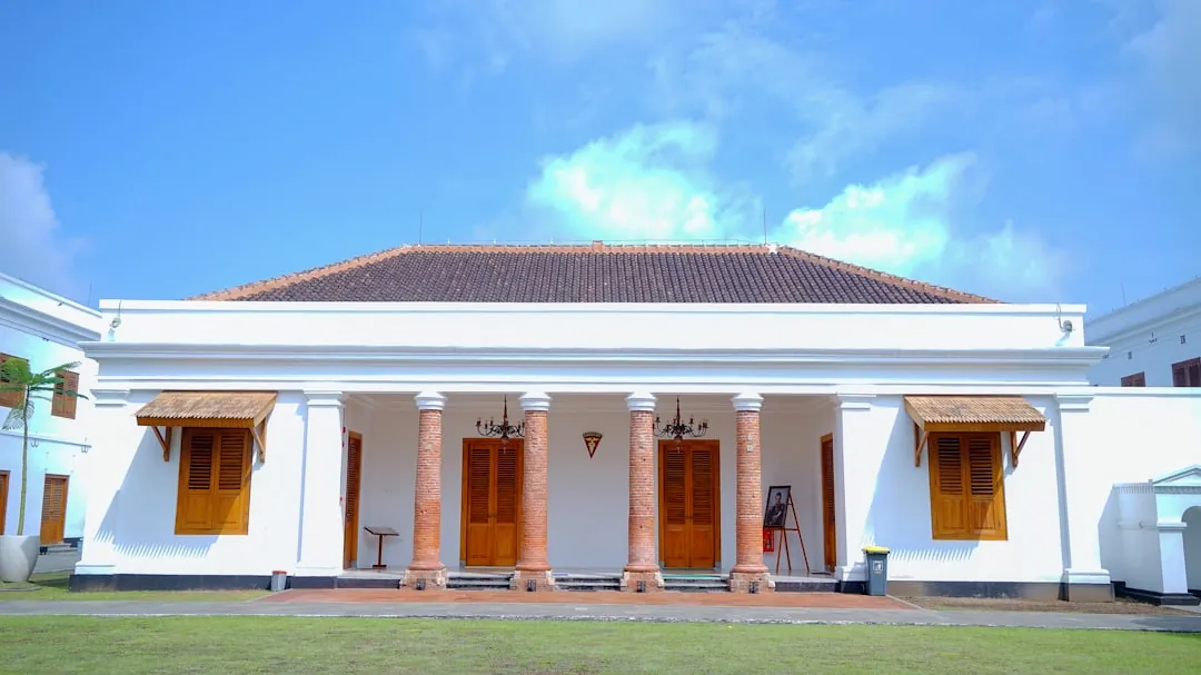 a large white building with columns and wooden doors