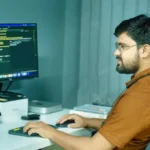 a man sitting at a desk using a computer