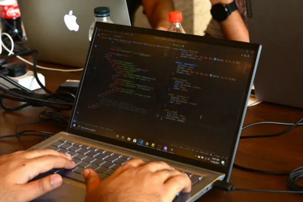 a man using a laptop computer on a wooden table