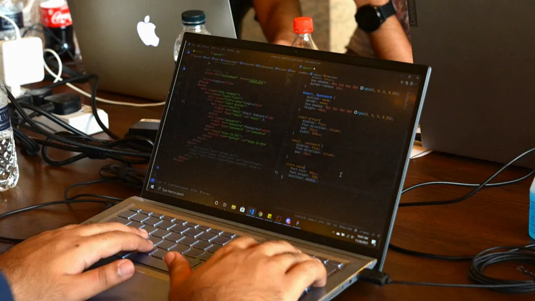 a man using a laptop computer on a wooden table