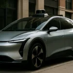 A midsize electric autonomous vehicle parked on a city street with visible sleek exterior design and urban surroundings during daytime.