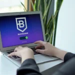 a person sitting at a table with a laptop