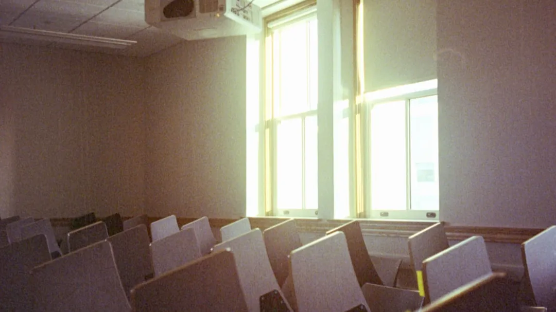 A room filled with lots of white chairs next to a window