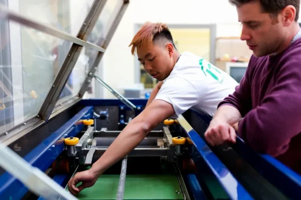 boy in white and purple long sleeve shirt playing with black and yellow plastic toy