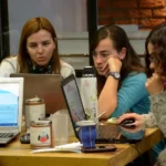 group of women sitting and using laptops