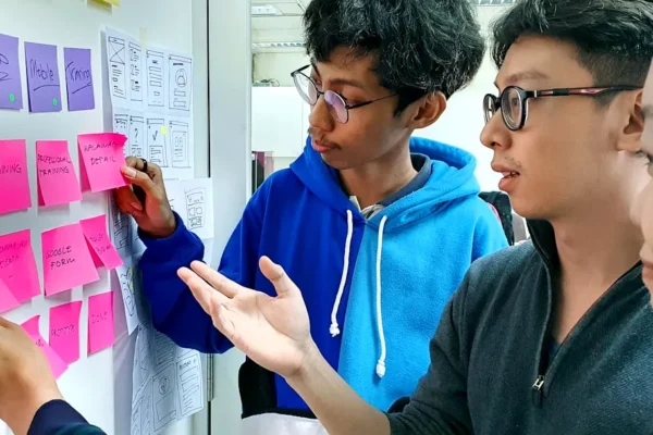 man in black framed eyeglasses holding purple and white box