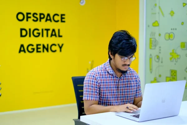 man in blue and white checkered dress shirt sitting on black chair