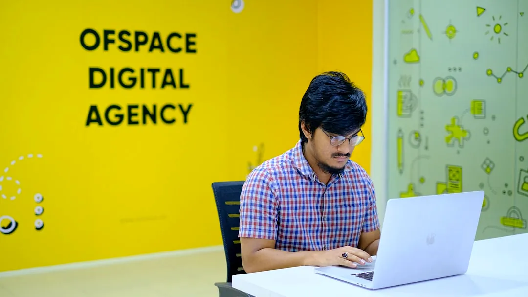 man in blue and white checkered dress shirt sitting on black chair