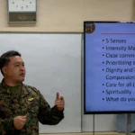 Man in military uniform presenting to a group.