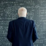 Professor studies complex formulas on a blackboard.