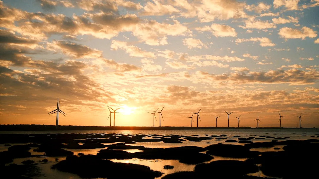 Wind turbines silhouetted against a sunset sky