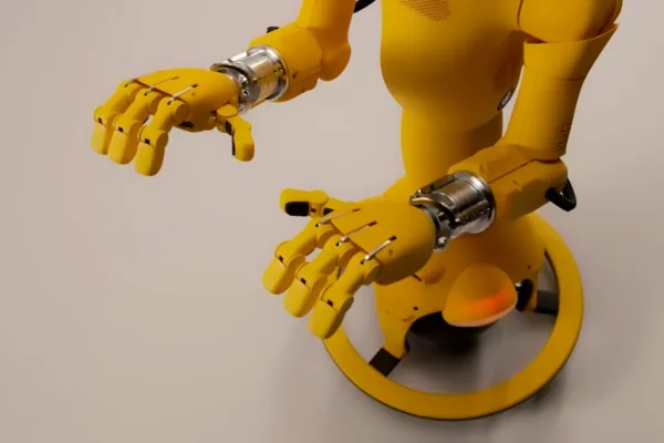 Yellow robot with articulated hands on a white background
