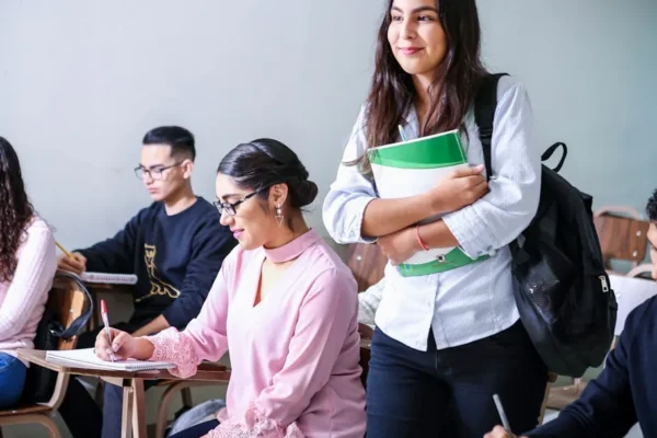 woman carrying white and green textbook